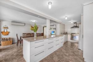 Una cocina grande con gabinetes blancos y una mesa. en Family Moments, en Anglesea