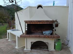 an outdoor brick oven with a large hood at Ellie Cottage Χαλάρωση στη Φύση in Ágios Nikólaos