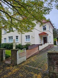 a white house with a gate in front of it at Pro Home Mara private Sauna in Bad Oeynhausen
