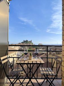 a balcony with a table and two glasses of wine at Las Vistillas in San Vicente de la Sonsierra +13 photos