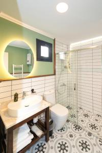 a bathroom with a sink and a toilet and a mirror at Urla Köstem Müze Otel in Uzunkuyu +30 photos