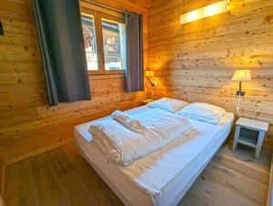 a bedroom with a large bed in a wooden room at Chalet le Panorama des Alpes à Guillestre in Guillestre
