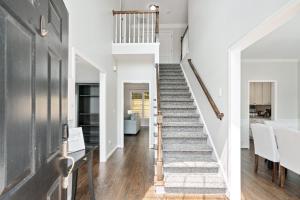 - un escalier dans une maison dotée de murs blancs et de parquet dans l'établissement Relaxing home close Six Flag 21 miles to airport, à Mableton