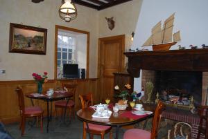 a dining room with two tables and a fireplace at Hostellerie de la Motte jean in Saint-Coulomb
