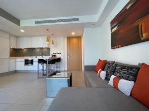 a living room with a couch and a kitchen at Oceanstone Condo 2 bedrooms BangTao Laguna in Bang Tao Beach