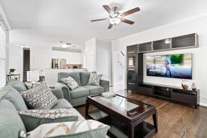 un salon avec un canapé et une télévision à écran plat dans l'établissement Relaxing home close Six Flag 21 miles to airport, à Mableton