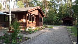 a small wooden cabin with a walkway in front at Ferienhaus Bea in Buchholz Aller
