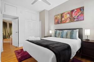 a bedroom with a large white bed and two paintings on the wall at Chic 1-BR Loft Nestled Between Dupont & Logan in Washington, D.C.