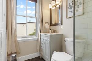 a bathroom with a toilet and a window at Chic 1-BR Loft Nestled Between Dupont & Logan in Washington, D.C. +19 photos