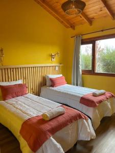 two beds sitting next to each other in a room at Ruca Nel in El Calafate