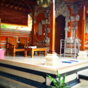 a room with a table and benches in a building at Arsa Homestay & Spa in Ubud