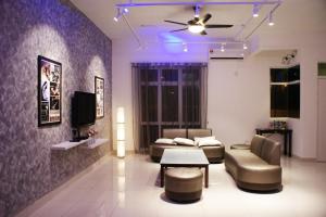 a living room with a couch and a tv at Shamrock Seaview 11 Villa in Batu Ferringhi