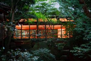 uitzicht op een tuin met een hek en bomen bij Fukuzumiro in Hakone