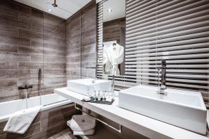 a bathroom with two sinks and a tub and a mirror at Hôtel Le White - Le 42 Restaurant in Champéry