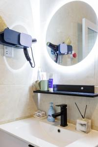 a bathroom sink with a mirror and a microscope at Chengdu city center Tianfu Square Kuanzhai Alley People's Park subway post-modern design 85 square meters 2 bedrooms 1 living room design B&B HD cinema family suite in Chengdu +37 photos