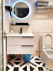 a bathroom with a sink and a mirror and a toilet at Chengdu city center Tianfu Square Kuanzhai Alley People's Park subway post-modern design 85 square meters 2 bedrooms 1 living room design B&B HD cinema family suite in Chengdu
