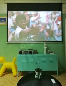 a flat screen tv on a green wall in a living room at Chengdu city center Tianfu Square Kuanzhai Alley People's Park subway post-modern design 85 square meters 2 bedrooms 1 living room design B&B HD cinema family suite in Chengdu