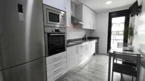a kitchen with white cabinets and a microwave at Vinalopó apartment con parking in Elche