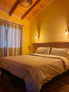 a bedroom with a large bed with a window at Ruca Nel in El Calafate