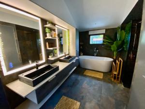 a bathroom with two sinks and a bath tub at La Cour de la Forêt in Saint-Mars-de-Coutais