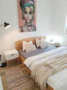 1 dormitorio con 2 camas y una pintura de una mujer en Centar Novi Sad-Apartman No 3 PARKING ON REQUEST, en Novi Sad