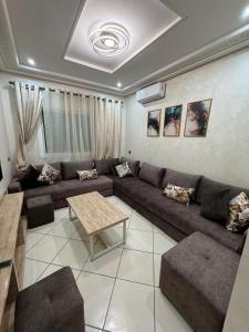 a living room with a couch and a table at Appartmojonera 306 in Beni Touzine