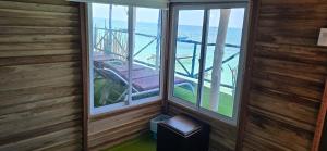 a room with two windows and a view of the ocean at Ecohotelhector in Playa Blanca