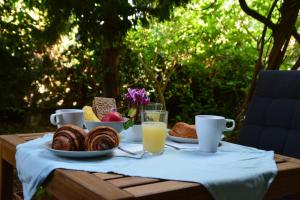 a table with a breakfast of bread and orange juice at Dunakorzo Apartman in Szentendre