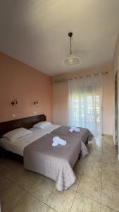 a bedroom with two beds with towels on them at Tsipos Rooms in Stavros