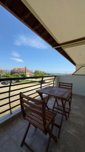 a table and a chair on a balcony with a view at Tsipos Rooms in Stavros