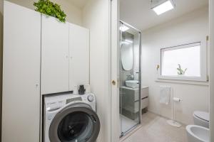 a bathroom with a washing machine and a sink at Loft Il Moro 2 Maranello Sassuolo Free Netflix & wi-fi in Casalgrande +15 photos