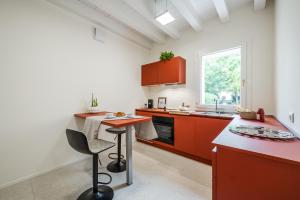 a kitchen with red cabinets and a red counter top at Loft Il Moro 2 Maranello Sassuolo Free Netflix & wi-fi in Casalgrande