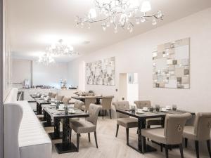 シャンペリーにあるHôtel Le White - Le 42 Restaurantのダイニングルーム(テーブル、椅子、シャンデリア付)