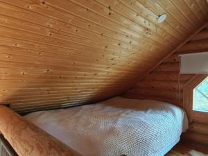 un letto in una stanza con soffitto in legno di Willa Axe a Hurissalo