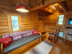a living room with a couch in a log cabin at Willa Axe in Hurissalo