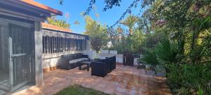 a patio with a couch and a table and chairs at Bungalow en Las Américas in Playa de las Americas
