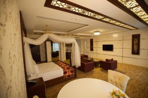 a bedroom with a bed and a living room at Mitannia Regency Hotel in Diyarbakır