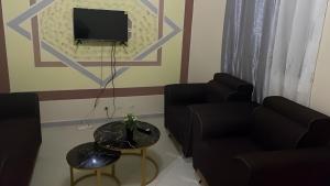 a living room with a couch and a tv and a table at Keur Massar Tolou Laye WADE in Niadyorane
