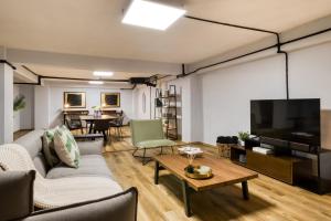 a living room with a couch and a flat screen tv at ULIV Apartments El Ángel in Mexico City