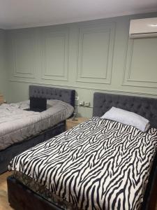 a bedroom with a zebra print bed with a laptop on it at Sweet Home villa in Tirana