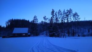 una casa in mezzo a una strada coperta di neve di Brīvdienu māja 1 a Kurmēni