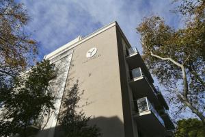 un edificio con un reloj al costado. en The Y Hotel, en Atenas