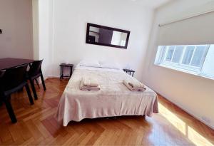 a bedroom with a bed and a table and a window at Amplio monoambiente en Microcentro in Buenos Aires