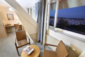 a room with two chairs and a table and a large window at Trinite Hotel in La Trinité-sur-Mer