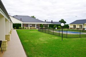 a fence in front of a yard with a pool at Roma Explorers Inn in Roma