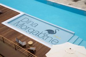 - une piscine avec un panneau indiquant un club mahoaho dans l'établissement Dina Morgabine Saint Gilles, à Saint-Gilles les Bains