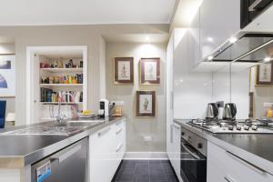 a kitchen with a sink and a stove top oven at Paddington Apartment By Morethanstays in London