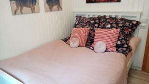 a bed with two pink pillows and a pink blanket at Ferienhaus Bea in Buchholz Aller