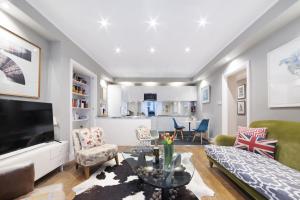 a living room with a couch and a table at Paddington Apartment By Morethanstays in London