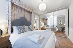 a bedroom with a large bed with towels on it at Paddington Apartment By Morethanstays in London